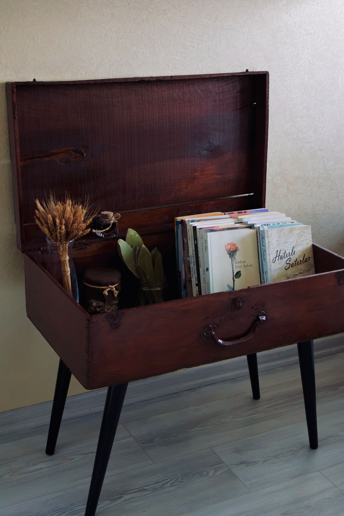 Vintage suitcase repurposed as decor with books and rustic accents