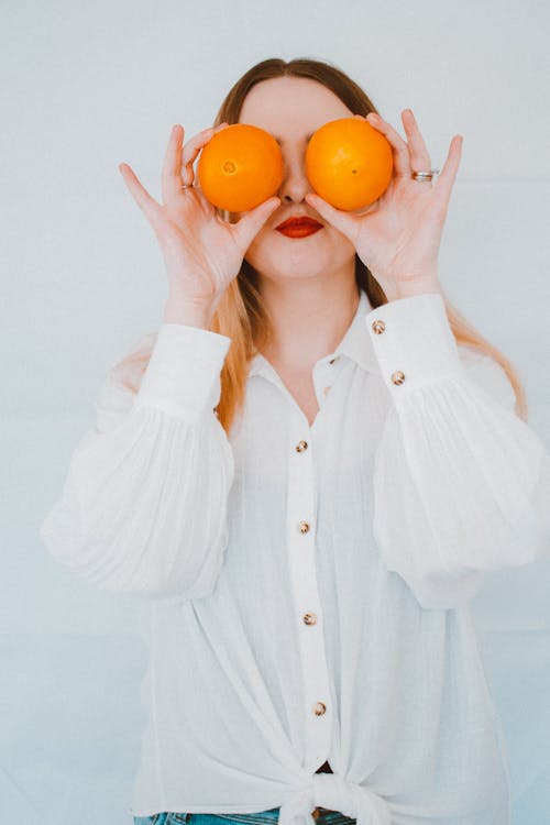 женщина I I белая рубашка с длинным рукавом на пуговицах с двумя оранжевыми фруктами