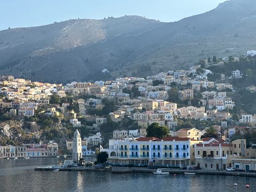 Free Charming hillside village of Symi Island with traditional architecture and serene harbor view. Stock Photo
