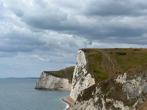 Free Dramatic view of the White Cliffs along Dorset's Jurassic Coast under a cloudy sky. Stock Photo