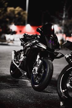 Powerful black motorcycle parked under city lights at night.
