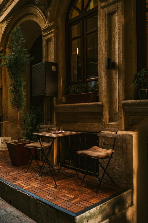 Free Cozy outdoor cafe table in Istanbul, Türkiye with rustic charm and historical architecture. Stock Photo