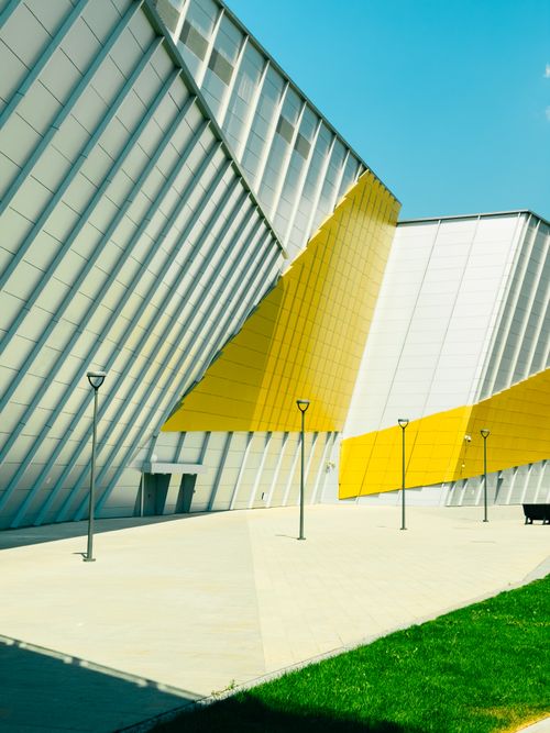 Free Dynamic modern architecture featuring angular designs and colorful facades under a clear sky. Stock Photo