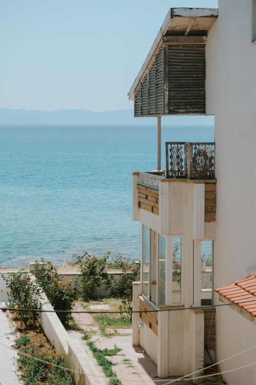 Free Serene seaside house with a stunning ocean view under a clear blue sky. Stock Photo