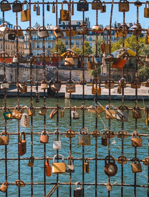 Free Padlocks symbolizing love on a bridge in Paris, overlooking the Seine River in daytime. Stock Photo