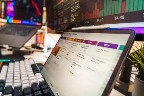 Free A dynamic office setup featuring multi-screen displays with data charts and project management tools, perfect for tech or business environments. Stock Photo