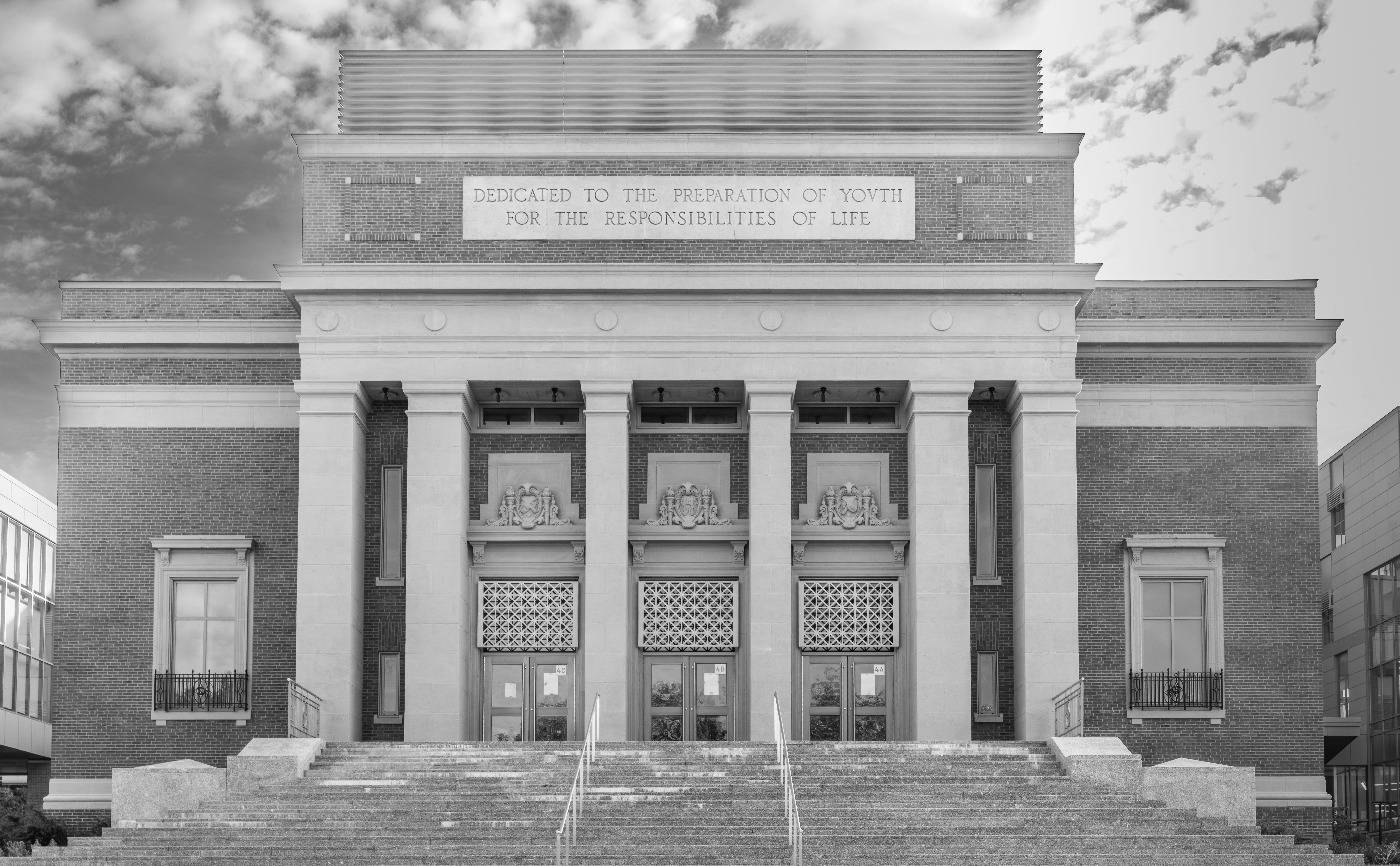 Black and white photo of a historic building facade with inspirational quote, Somerville, Massachusetts.