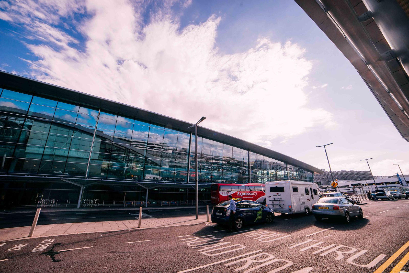 Cars and buses outside a general airport terminal building