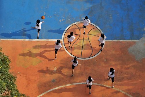 Free Aerial shot of girls playing basketball in an outdoor court in Jakarta, Indonesia. Stock Photo