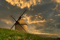 法国乡村戏剧性的日落天空下，映衬着迷人的风车轮廓