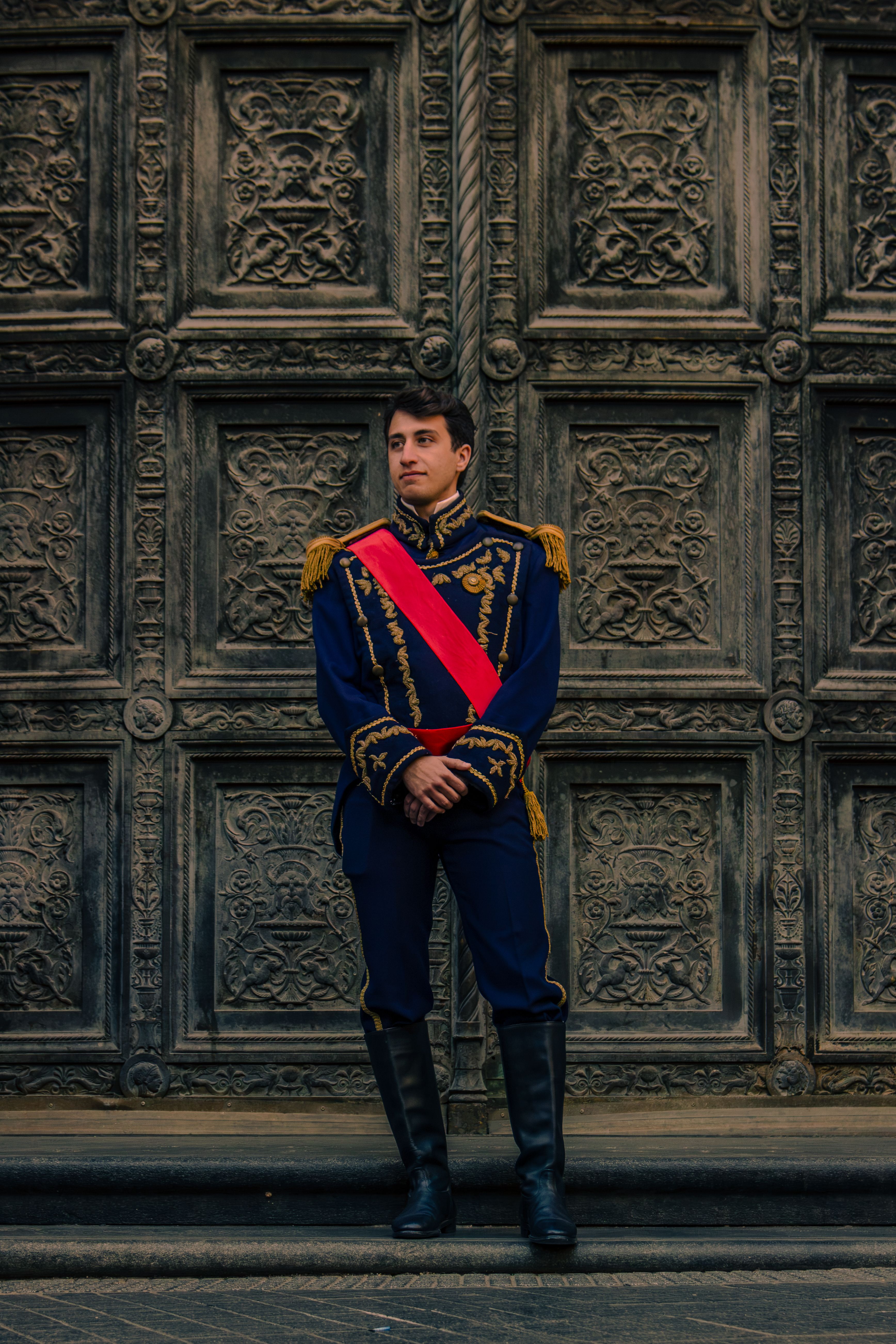 A guard in a historical uniform stands by an ornate door in Buenos Aires.