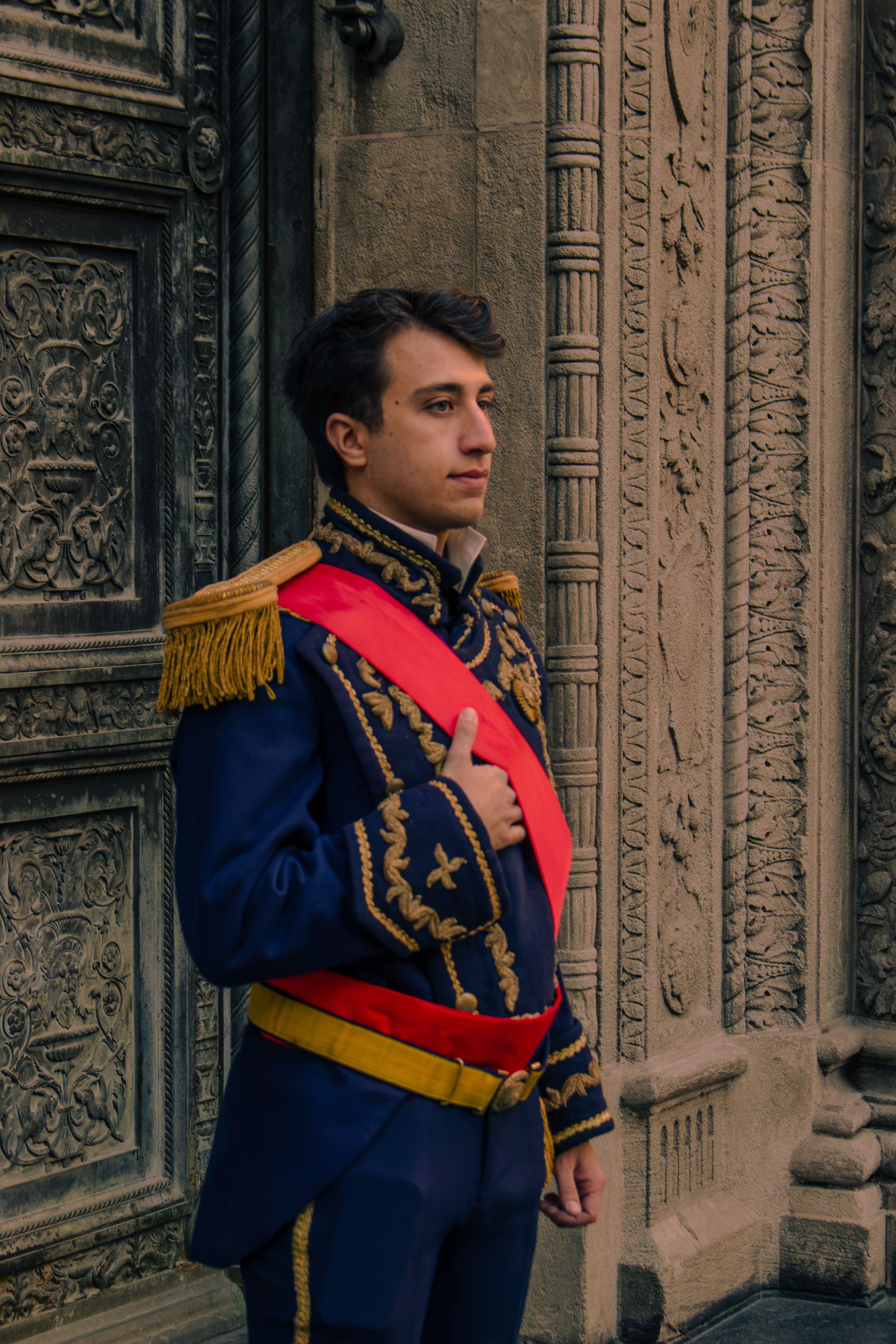 Portrait of a man in traditional Argentinian uniform by ornate architecture in Buenos Aires.
