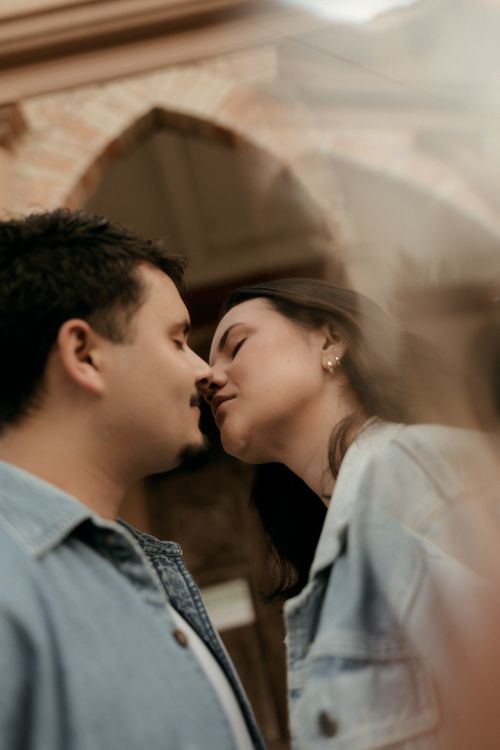 Free Close-up of a couple leaning in for a kiss, creating a romantic atmosphere. Stock Photo