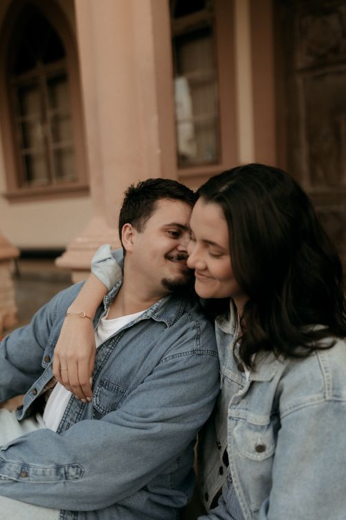 Free A young couple embraces lovingly in a casual denim setting outdoors. Stock Photo
