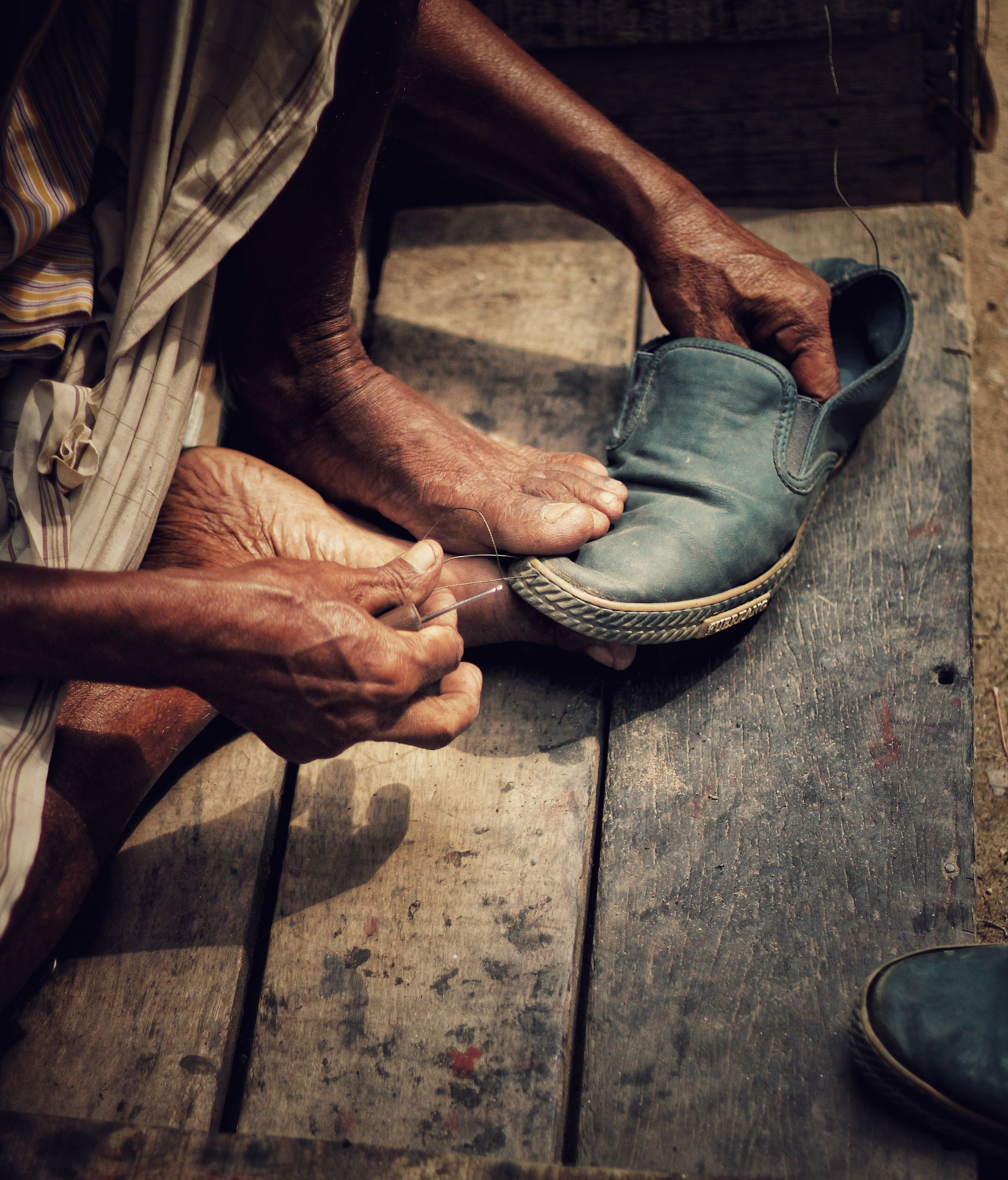 Detailed view of a skilled artisan repairing a shoe by hand, showcasing traditional craftsmanship.