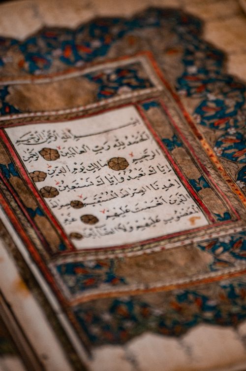 Free Close-up of an ornate Islamic manuscript featuring Arabic calligraphy with elaborate designs. Stock Photo