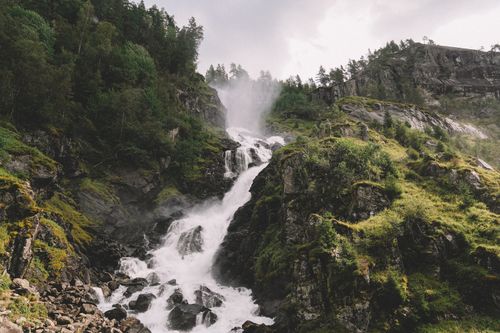 Free Explore the natural beauty of a lush mountain scene with a cascading waterfall and vibrant greenery. Stock Photo