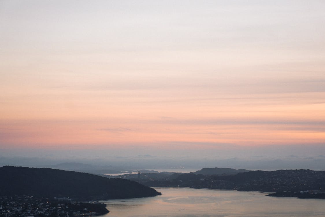 Body Of Water Near Mountains During Sunset