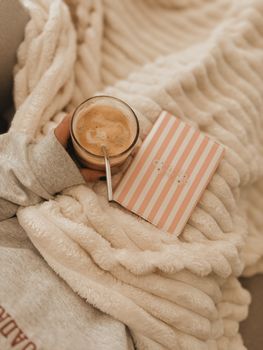 Warm and cozy setting with a coffee cup and journal on a soft blanket.