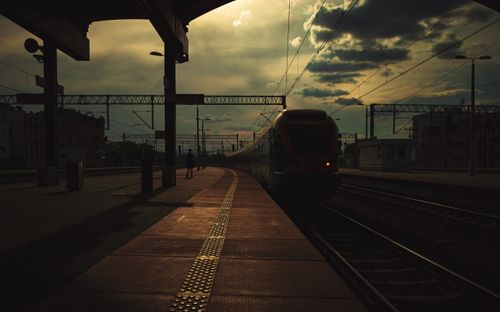 Free Silhouetted train at sunset in Katowice station, capturing a dramatic and moody atmosphere. Stock Photo