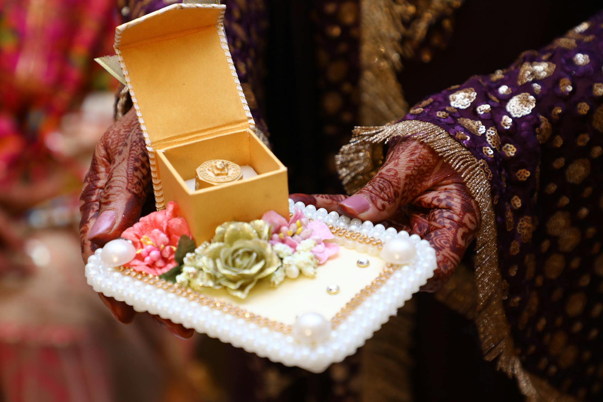 Beautifully decorated gift box with jewelry presented at a vibrant Indian wedding ceremony.