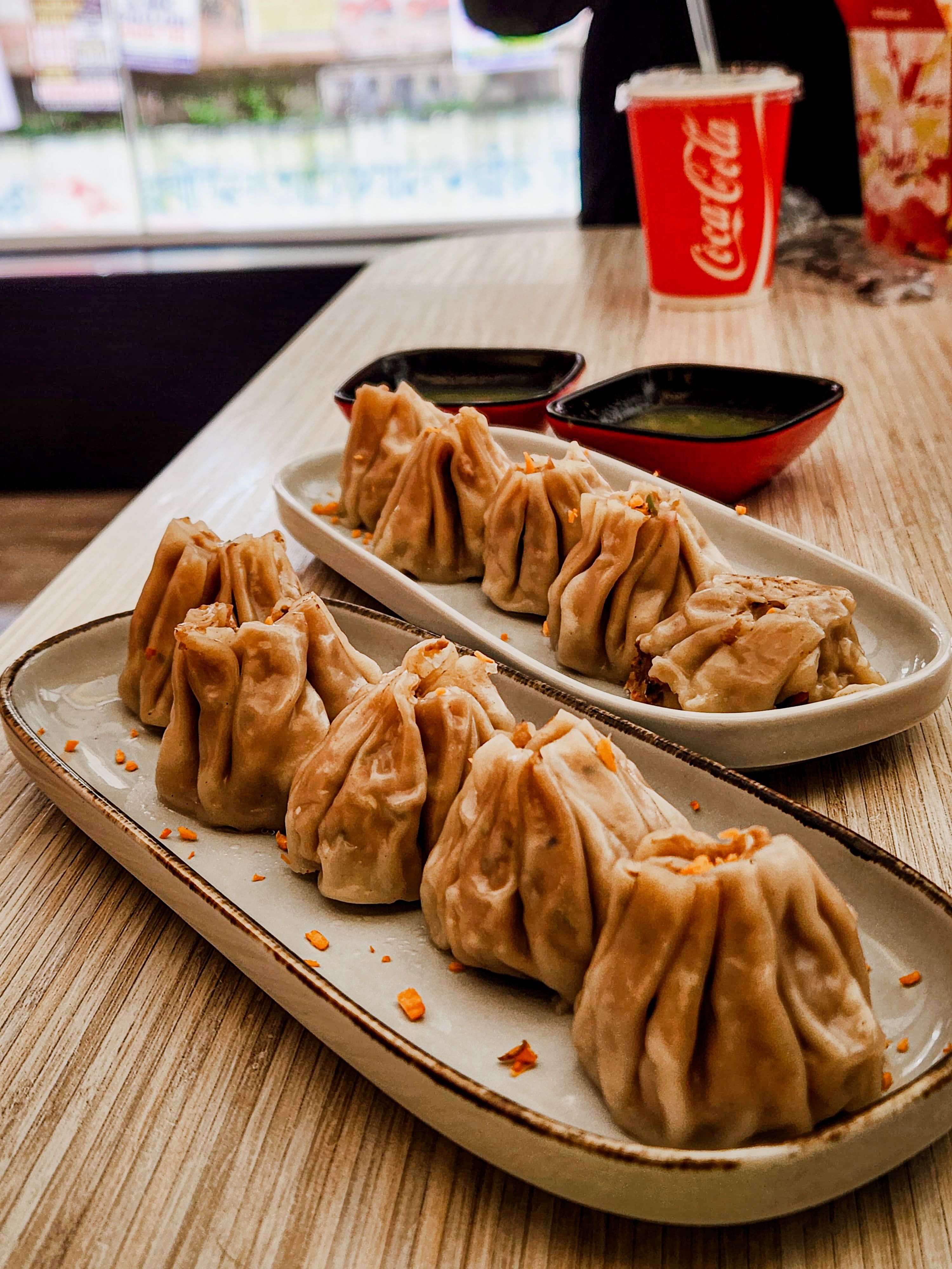 Plate of steamed dumplings served with dipping sauces at a restaurant in Dhaka, Bangladesh.