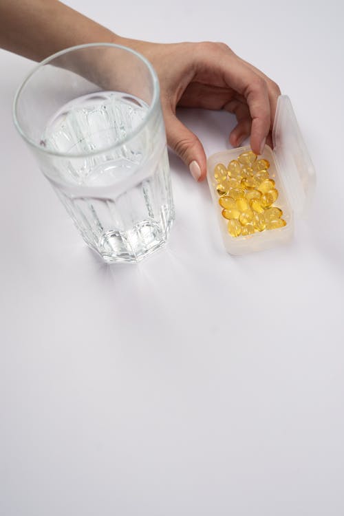 Clear Drinking Glass Beside Vitamins