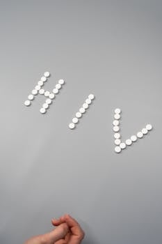 Artistic representation of HIV with pills on a gray surface, symbolizing medical treatment.