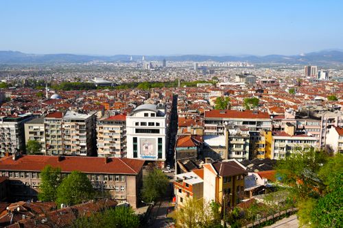 Free A sprawling aerial view of Plovdiv, Bulgaria, showcasing the city's architecture, greenery, and distant hills under a clear sky. Stock Photo