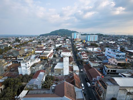 Aerial view of Salatiga cityscape in Central Java, showcasing urban landscape and distant green hills.