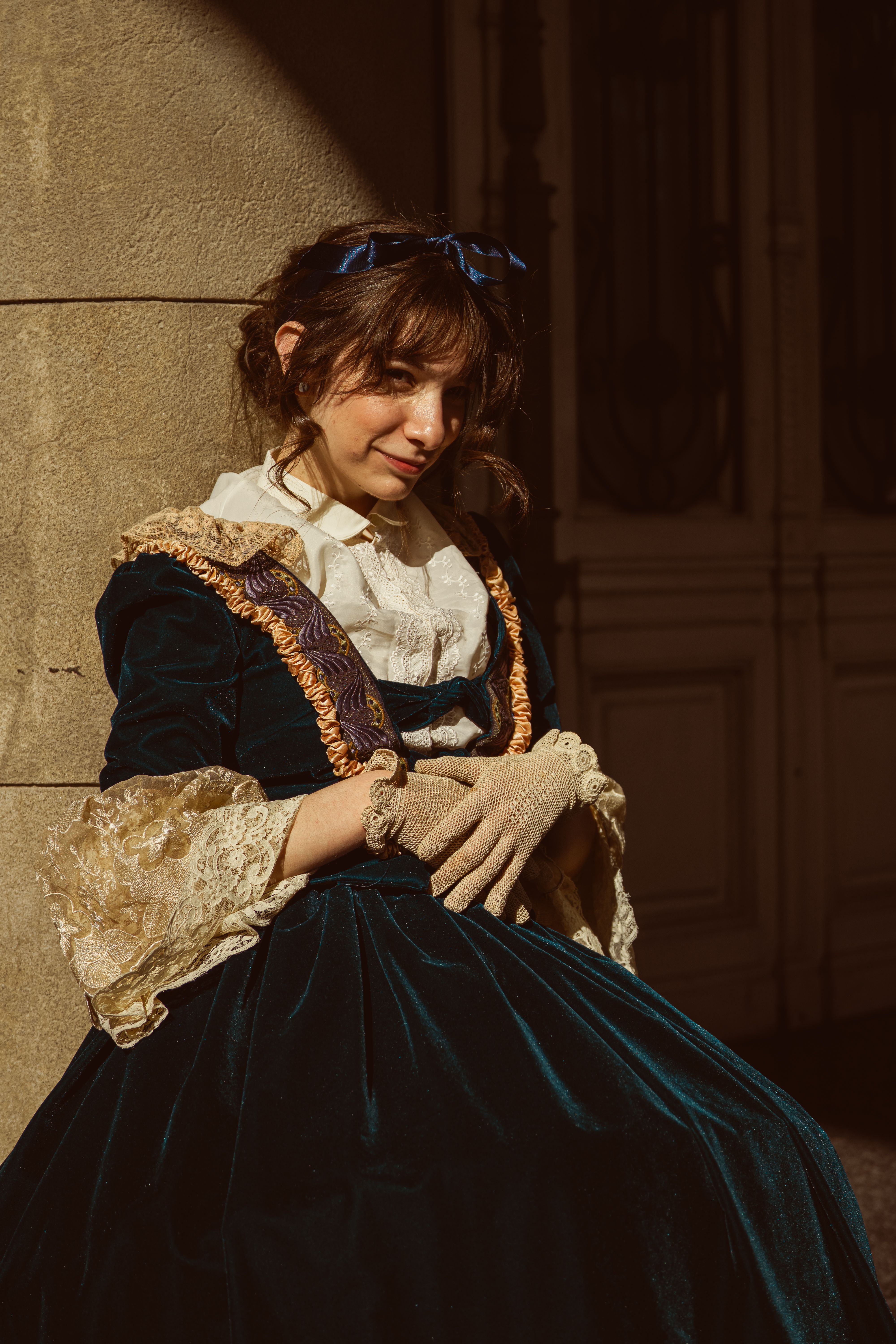 Portrait of a woman in Victorian dress, sitting gracefully in the streets of Buenos Aires.
