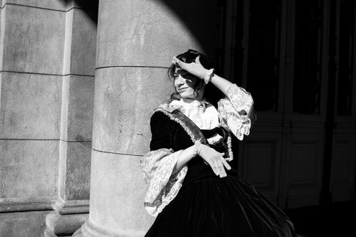 Free A woman in Victorian attire poses against a column in Buenos Aires, Argentina. Stock Photo