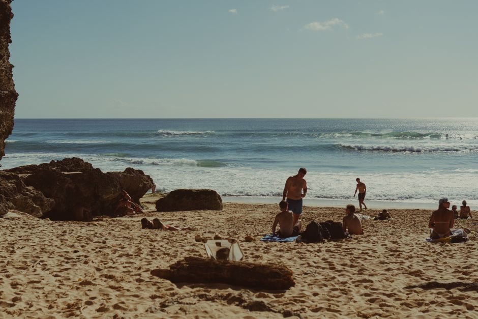 A serene day at a Bali beach with people lounging and enjoying the sun and sea.