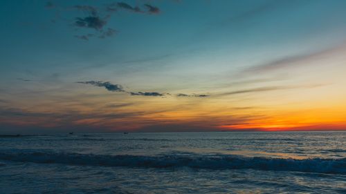 Free Serene sunset view over ocean with vibrant colors and gentle waves. Stock Photo