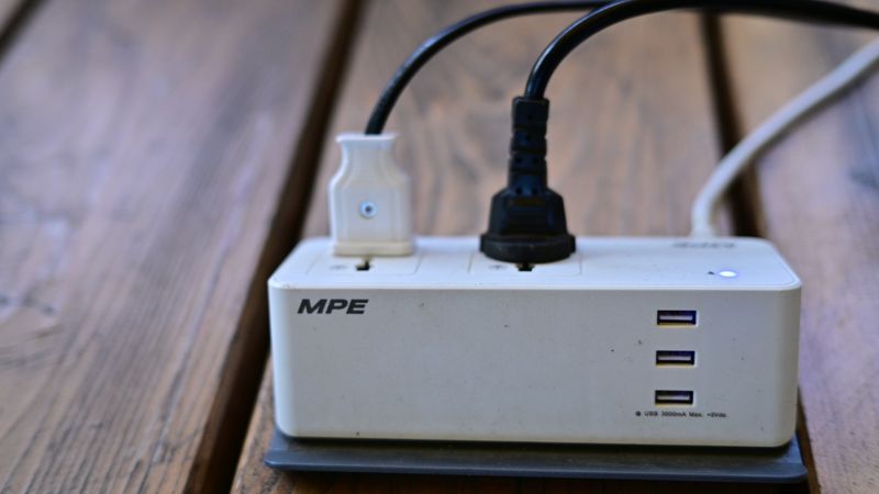level 1 charging cable covered in light snow connected to an electric vehicle outdoors