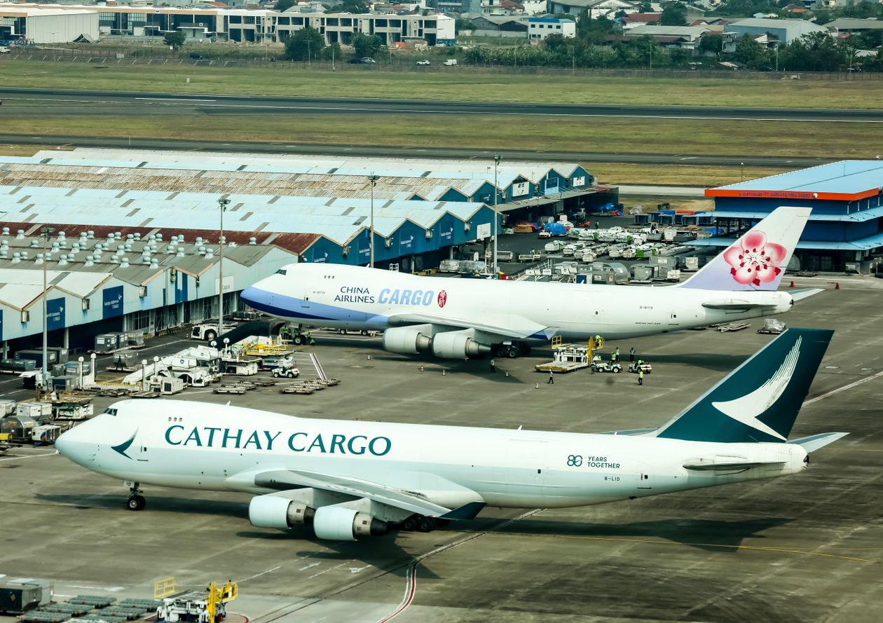 Cargo airplanes parked at a busy airport cargo terminal