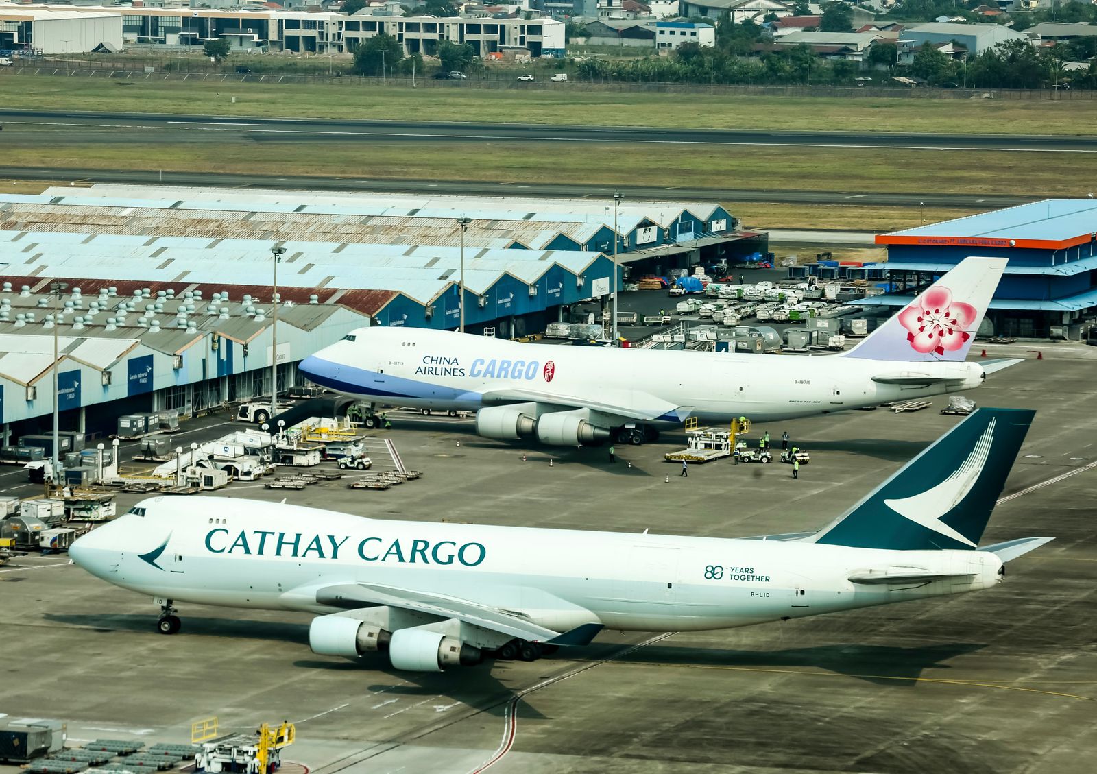 Cargo airplanes parked at a busy airport cargo terminal