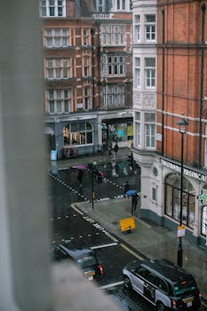 A rainy street scene in Marylebone, London showcasing classic architecture and urban life.