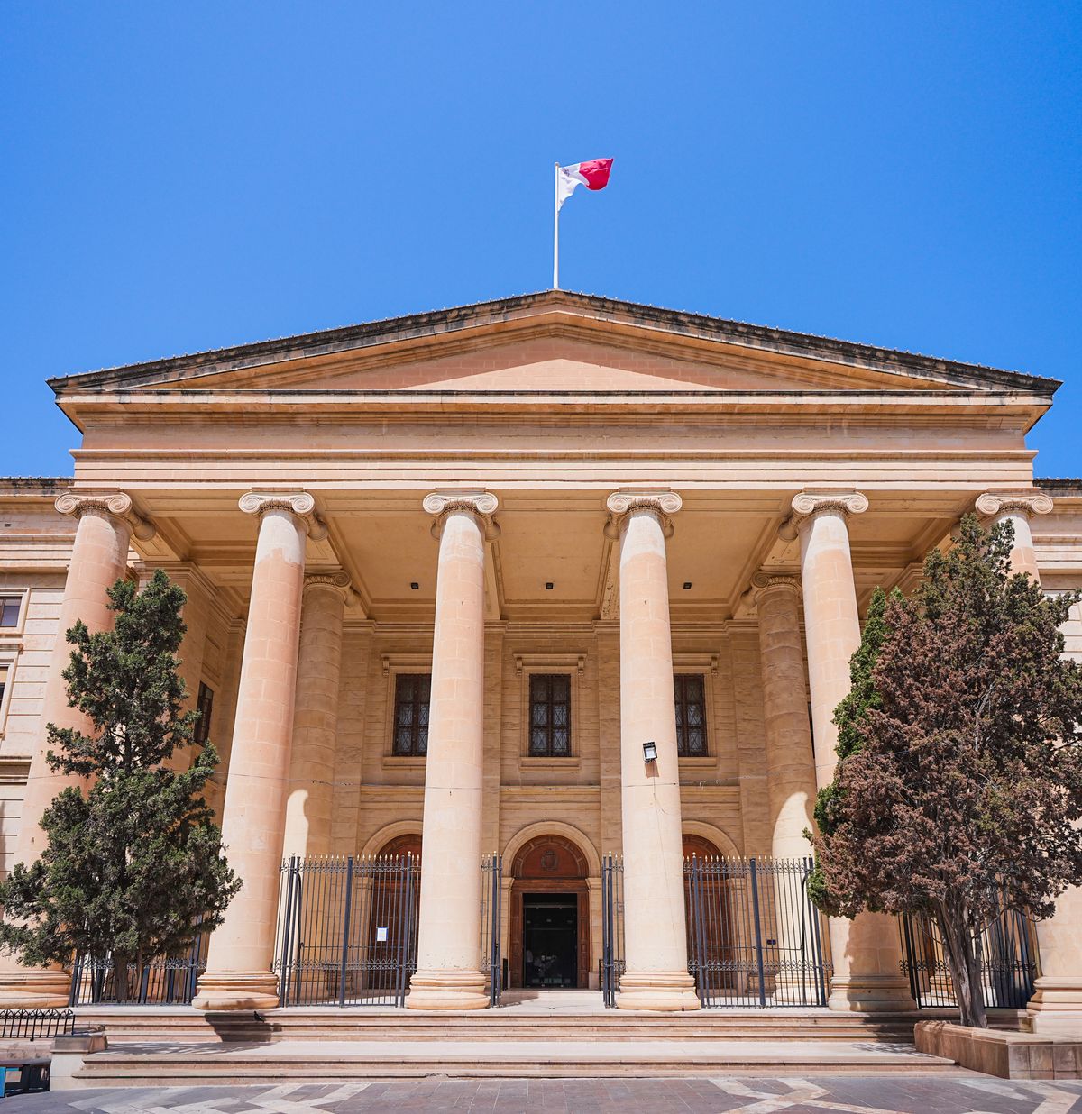 Courthouse with stone columns under a blue sky