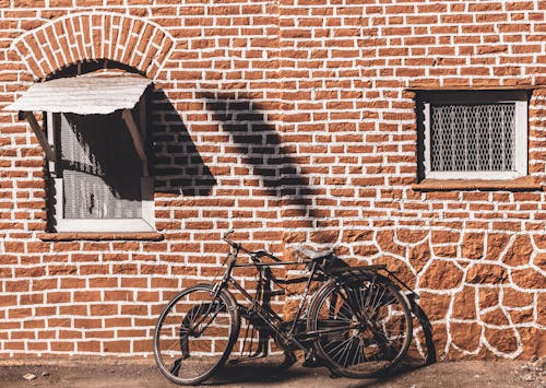 Gratis stockfoto met bakstenen muur, fietsen, geparkeerd