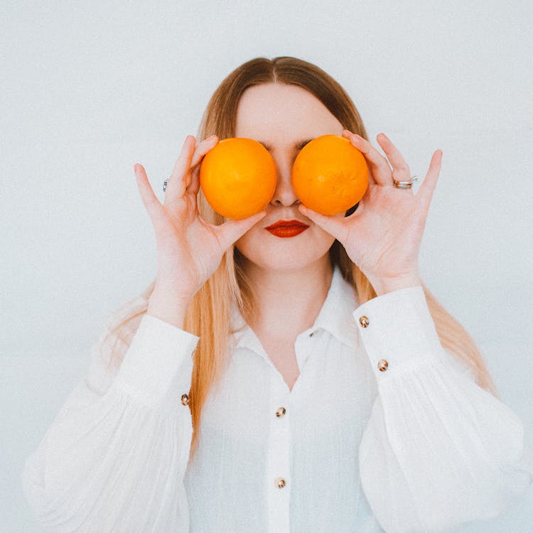 Woman In White Button Up Shirt Holding Two Oranges