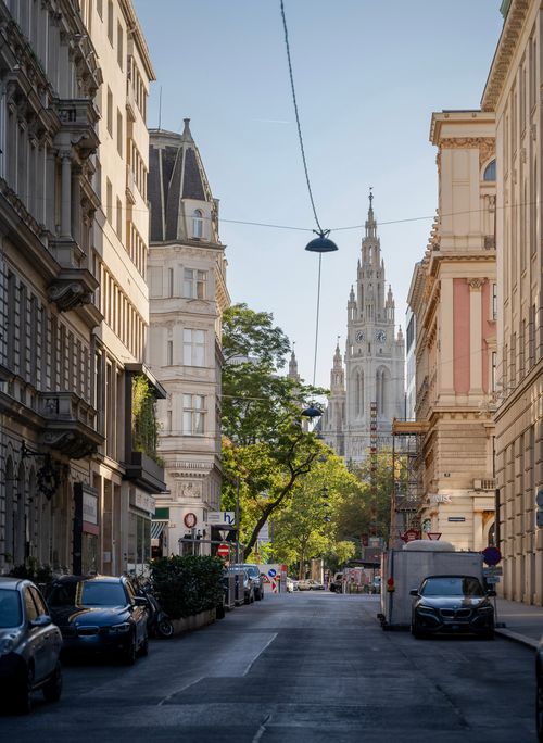 Free A stunning view down a quiet Vienna street, showcasing the iconic Rathaus in the distance. Stock Photo