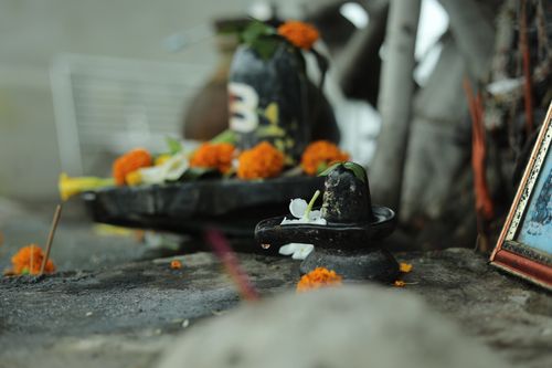 Free Small Shiva Lingam decorated with marigold flowers, offering spiritual ambiance and cultural depth. Stock Photo