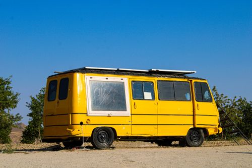 Free A vibrant yellow van parked outdoors on a sunny day in Türkiye. Stock Photo