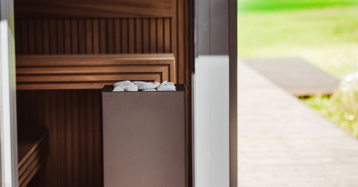 Contemporary outdoor sauna featuring wood panels and an electric heater with stones.