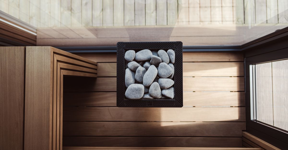 Explore the elegant design of a modern Nordic sauna featuring a stone heater and wooden benches.