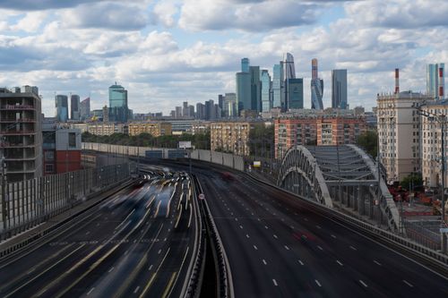 Free A view of Moscow's skyline featuring modern skyscrapers and a busy highway under a cloudy sky. Stock Photo