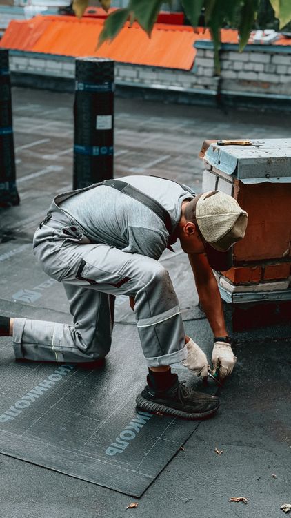 Roofer in protective clothing working on a rooftop on a sunny day