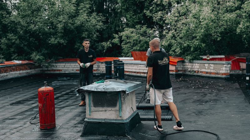 Workers performing maintenance on a flat commercial roof