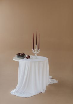 Sophisticated table with candles and pinecones, perfect for elegant events.